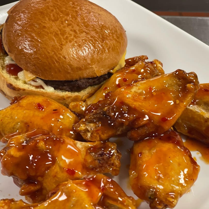 A & Burger slider with cheese, ketchup, and mayo, served with sweet chili glazed wings.